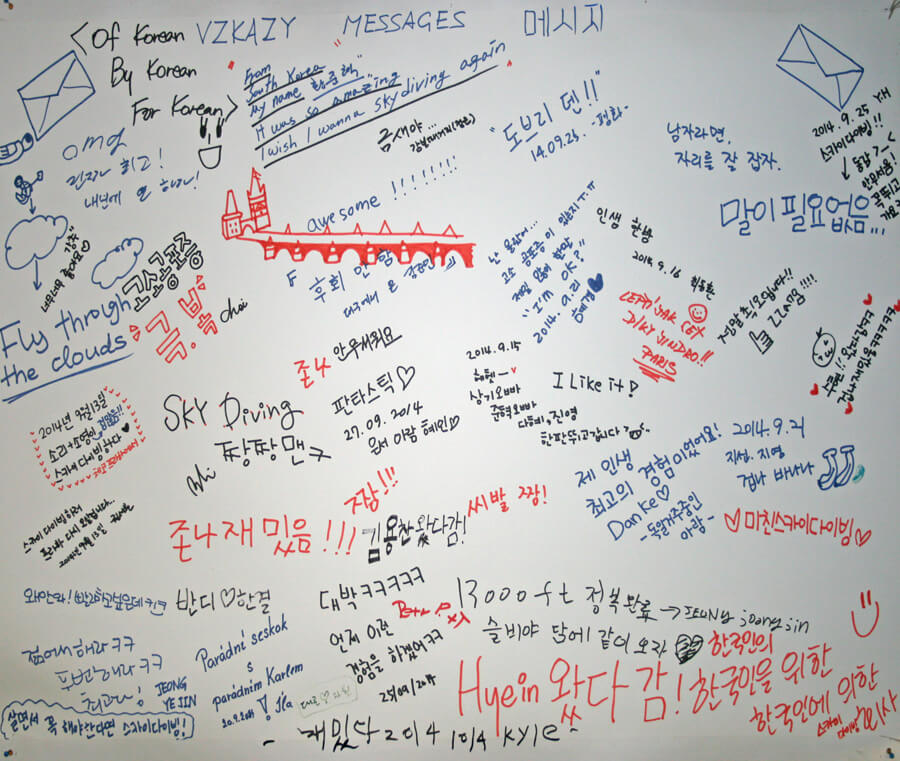 The message wall in the Skydive Kantor hangar with its heading in three languages: VZKAZY, MESSAGES and 메시지